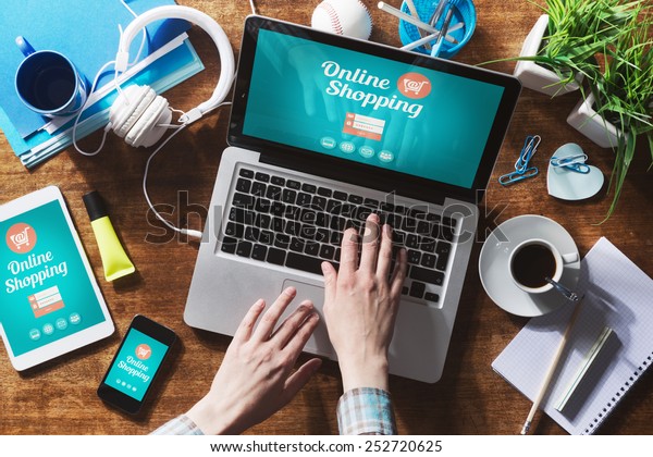 Online shopping website on laptop screen with female hands typing