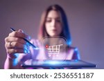 Online shopping. Woman places item in shopping cart on tablet computer. Digital shopping technologies. Blurred girl makes purchases in online store. Woman entrepreneur trading on marketplace