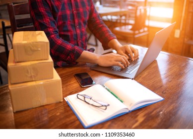 Online Shopping Young Start Small Business In A Cardboard Box At Work. The Seller Prepares The Delivery Box For The Customer, Online Sales, Or Ecommerce.