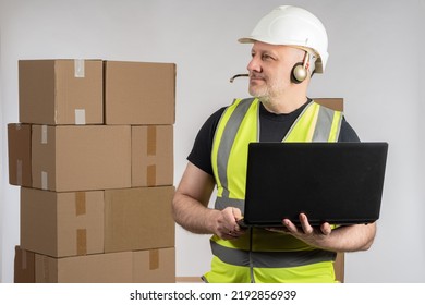 Online Store Employee. Man With Laptop To And Headphones Dispatcher. Online Store Manager Near Boxes. E-commerce Dispatcher Career. Warehouse Worker In White Helmet. Warehouse Manager On Dispatcher