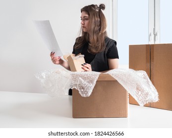 Online store and  Product packaging. A girl is packing goods for delivery. A packer with a bill of lading in her hands. 