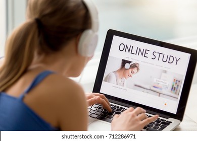 Online Study Concept, Woman In Headphones Searching Free Audio Course For Individual Self-tuition, Student Using Laptop For E-learning, Distance Learning, Rear View Over Shoulder, Focus On Screen