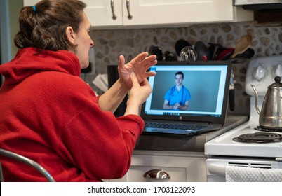 Online Telehealth visit with a woman who hurt her hand in the kitchen. Medical video visit concept.