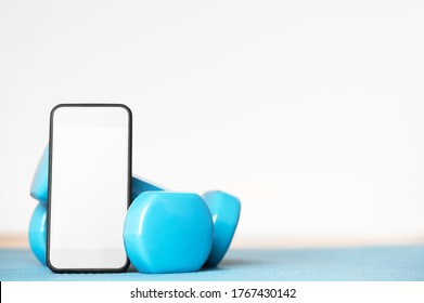 Online Training. Sport Tools For Workout At Home. Dumbbells And Smartphone With Empty Screen. Mockup On Display Of Cellphone. Healthy Lifestyle. Isolation Period. Home Exercises Concept