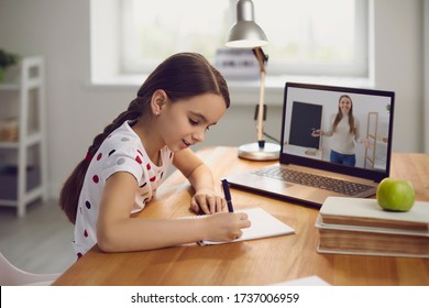 Online Training. The Teacher Teaches The Child A Video Call Chat Classroom Video Conferencing. Little Girl Teach A Lesson Using A Laptop With Sitting At A Table At Home.