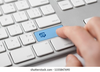Online translator and language e-learning course concept. Computer user press keypad on keyboard with symbol of translation (speech bubble with arrows and abstract text).