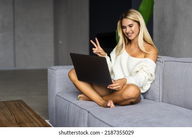 Online Video Call And Communication. Portrait Of Smiling Lady Using Laptop For Virtual Conference, Talking With Friends Or Family Waving Hand To Webcam, Cheerful Casual Female Sitting On Couch At Home