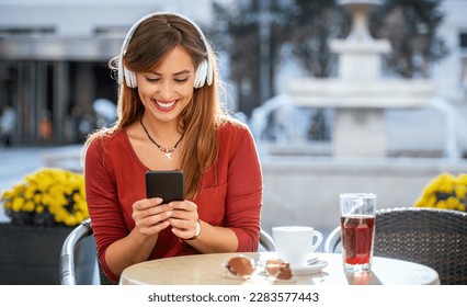 Online video communication. Young woman sitting in a cafe and having communication with friends by using video call on smartphone. Lifestyle, technology - Powered by Shutterstock