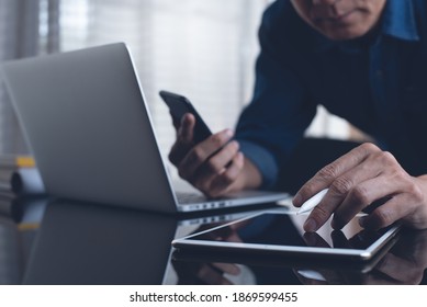 Online working, internet network, business technology concept. Multitasking business man with stylus pen touching on digital tablet, using smart phone, working on laptop computer in office, close up - Powered by Shutterstock