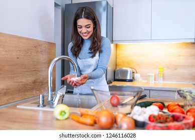 Only Clean And Fresh Veggies For My Salad. Beautiful Young Woman Washing Vegetables For Salad And Smiling While Standing In The Kitchen. Vegetables In The Sink On Kitchen. Homemade Food Concept.