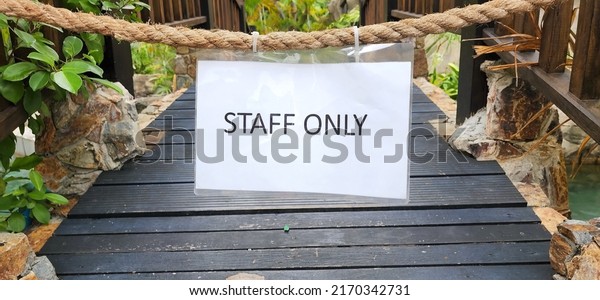 Only the employees sign with black letters on\
a white paper with waterproof plastic coating. Signs are hung on\
manila ropes installed on railings of wooden bridges to prevent\
outsiders from entering. 