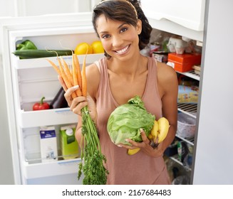 Only The Most Healthy Ingredients For Me. Portrait A Young Woman Holding Fresh Produce In A Kitchen.