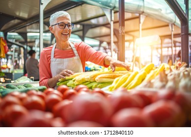 Only organic. Fresh from the earth. I am proud of my produce. Female farmer with vegetables. Friendly woman tending an organic vegetable stall at a farmer. Senior woman selling vegetables - Powered by Shutterstock