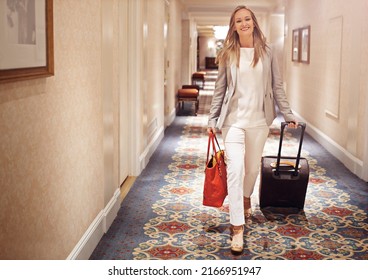 I Only Stay At The Best. Shot Of A Woman Walking Down The Corridor Of A Hotel With A Suitcase.