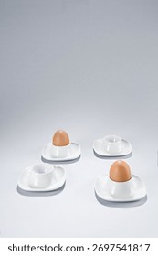 Only two eggs in an eggcups and two more are empty. Copy space, vertical.