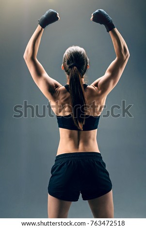 Similar – Rear view portrait of one young middle age athletic woman at crossfit training, exercising with trx suspension fitness straps over dark background