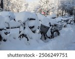 Onset of winter in the English Garden in Munich, Bavaria, Germany: Snowy bicycles at the entry to the park, a bizarre scene