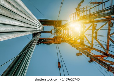 Onshore Land Rig In Oil And Gas Industry. Oil Drilling Rig Against A Blue Sky With Clouds.