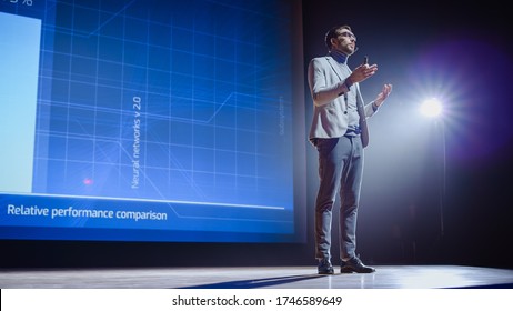 On-Stage: Speaker Does Presentation Of The New Electronic Product, Shows Infographics, Statistic Animation On Screen. Auditorium Hall Live Event, Start-up Conference, Device Presentation And Release