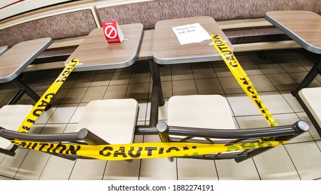 ONTARIO CANADA - DEC 12 2020: Yellow Tape With The Word Caution Placed Around Tables And Chairs Inside Tim Horton's Due To Covid-19 Pandemic.  Tim Horton's Is A Fast Food Restaurant Chain In Canada.