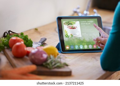 Ooh This One Looks Nice.... Cropped Shot Of A Young Woman Looking At An Online Recipe On Her Digital Tablet While Preparing A Meal.