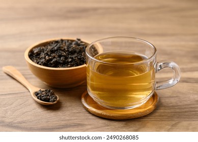 Oolong tea in cup glass with dried Oolong tea leaves on wooden background, Healthy drink