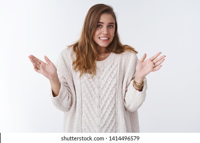 Oops sorry my fault. Portrait awkward guilty cute silly woman making mistake apologizing stooping clenching teeth uncomfortable feeling raising palms surrender, standing white background worried