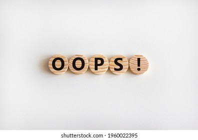 Oops Symbol. Oops Sign On Wooden Cut Circles. Beautiful White Background, Copy Space. Business And Oops Concept.