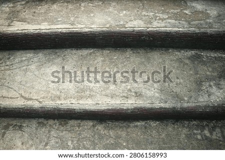 op-down close up view of weathered old concrete staircase steps with dark wooden edging showing grunge texture and abstract architectural detail