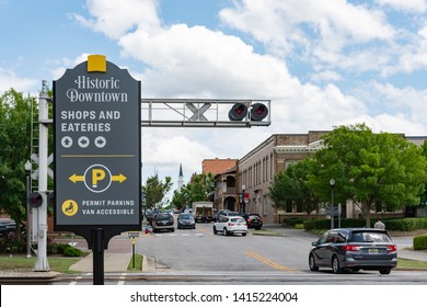 Opelika, Alabama/USA-May 10, 2019: Historic Downtown Sign Near The Railroad Tracks With Downtown Opelika Traffic In The Background.