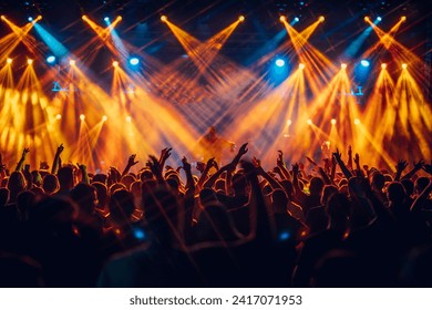 Open air music festival with crowd in foreground having fun, dancing and rising their hands. A performer is singing on stage during the concert while silhouettes of people having fun at concert. - Powered by Shutterstock