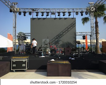 Open air show stage set up with led screen, sound and light system. Back line with drums. Horizontal image