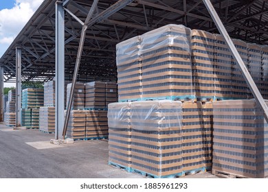 The Open Air Storage And Carriage Of The Finished Product At Industrial Facility. A Glass Clear Bottles For Alcoholic Or Soft Drinks Beverages And Canning Jars Stacked On Pallets For Forklift.