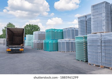 The Open Air Storage And Carriage Of The Finished Product At Industrial Facility. A Glass Clear Bottles For Alcoholic Or Soft Drinks Beverages And Canning Jars Stacked On Pallets For Forklift.