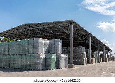 The Open Air Storage And Carriage Of The Finished Product At Industrial Facility. A Glass Clear Bottles For Alcoholic Or Soft Drinks Beverages And Canning Jars Stacked On Pallets For Forklift.