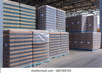 The Open Air Storage And Carriage Of The Finished Product At Industrial Facility. A Glass Clear Bottles For Alcoholic Or Soft Drinks Beverages And Canning Jars Stacked On Pallets For Forklift.