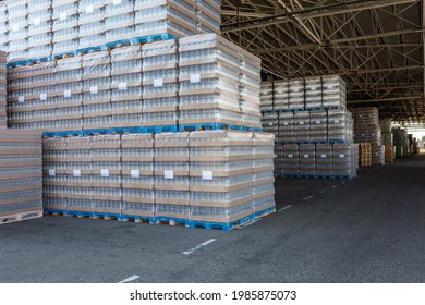 The Open Air Storage And Carriage Of The Finished Product At Industrial Facility. A Glass Clear Bottles For Alcoholic Or Soft Drinks Beverages And Canning Jars Stacked On Pallets For Forklift.