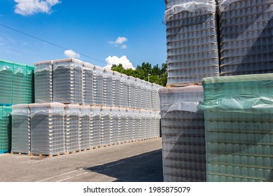 The Open Air Storage And Carriage Of The Finished Product At Industrial Facility. A Glass Clear Bottles For Alcoholic Or Soft Drinks Beverages And Canning Jars Stacked On Pallets For Forklift.