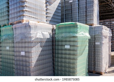 The Open Air Storage And Carriage Of The Finished Product At Industrial Facility. A Glass Clear Bottles For Alcoholic Or Soft Drinks Beverages And Canning Jars Stacked On Pallets For Forklift.