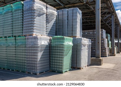 The Open Air Storage And Carriage Of The Finished Product At Industrial Facility. A Glass Clear Bottles For Alcoholic Or Soft Drinks Beverages And Canning Jars Stacked On Pallets For Forklift.