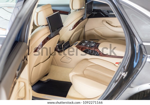 Open back door of business class car. Rear seat
of modern luxury vehicle. Interior of limousine with entertainment
system climate control and facilities for comfort. Rent  car with
driver concept