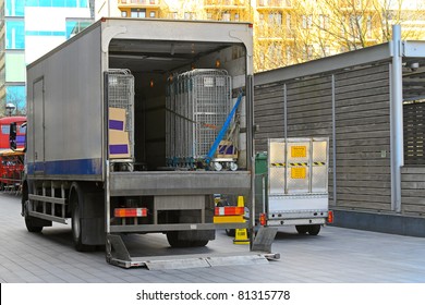 Open Back Door Of Delivery Truck Parked Outside Store