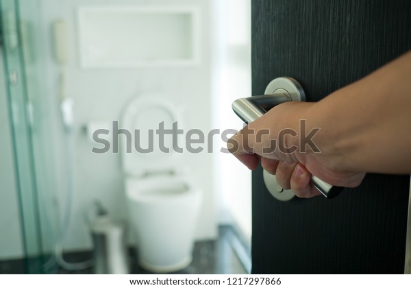 Sick young woman leaning on open toilet seat an vomiting 