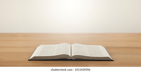 Open Bible Book On A Wooden Table.