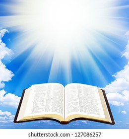 Open Bible Book Over Sky Background