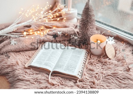 Open Bible in cozy pink winter home morning atmosphere.