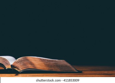 Open Bible on black background - Shutterstock ID 411853009