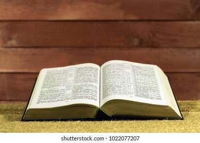 Open Bible on a Gold table. Beautiful red wooden background.Religion concept. - Shutterstock ID 1022077207