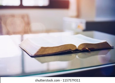 Open Bible On Office Desk With Window Light Reflected, Christian Background With Copy Space.