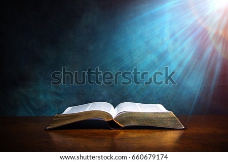 Open Bible on a wood table with light coming from above. ( Church concept. )
